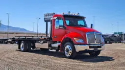 Red tow truck with a black flatbed.