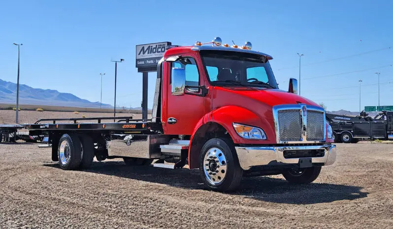 Red tow truck with a black flatbed.