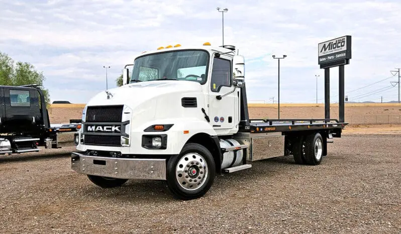 White Mack tow truck with a flatbed.