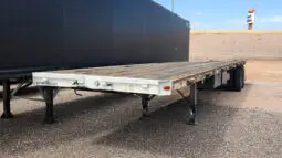 White flatbed trailer with black wheels.