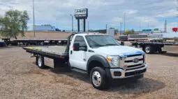 White Ford tow truck in a lot.