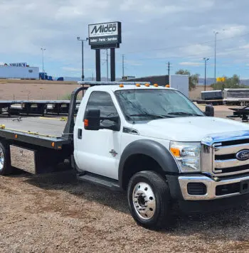 White Ford tow truck in a lot.