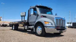 Gray Peterbilt flatbed tow truck.