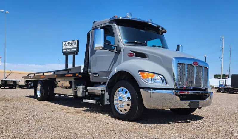 Gray Peterbilt flatbed tow truck.