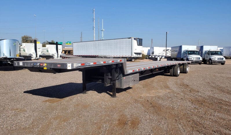 Flatbed semi trailer parked in a gravel lot