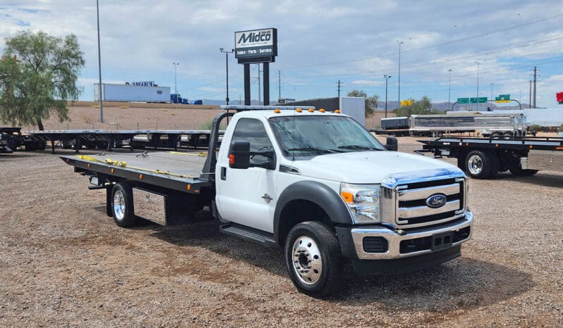 White Ford tow truck in a lot.