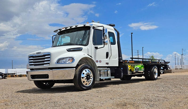 White flatbed tow truck parked outdoors.