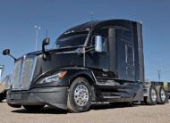 2022 kenworth T680 black sleeper cab truck - 02 - front grill, side angle view